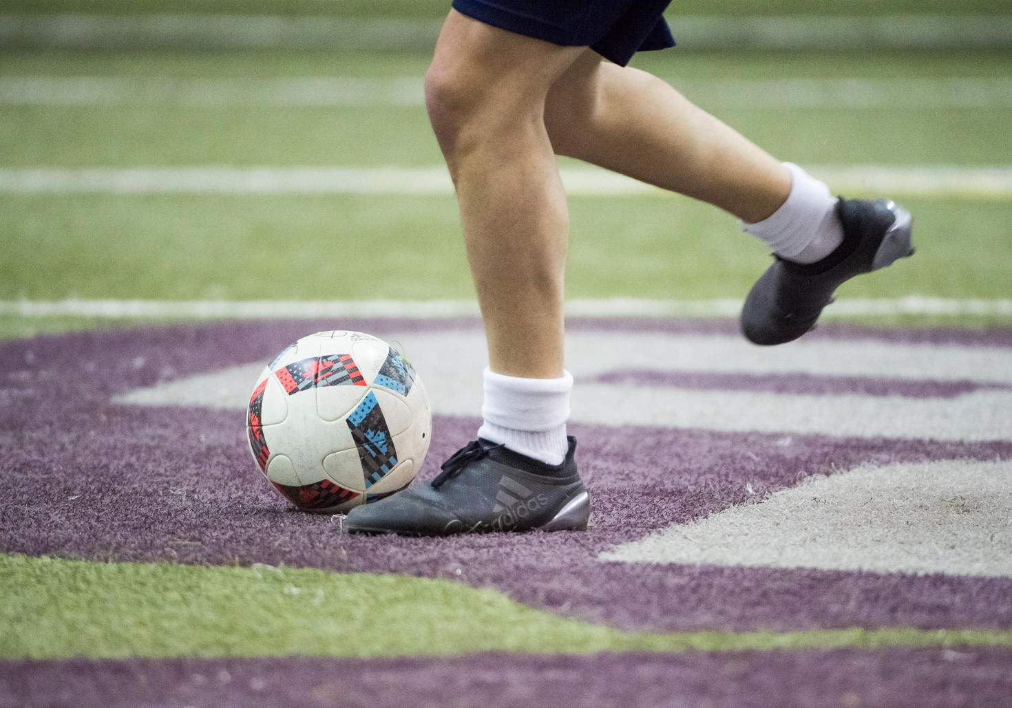 Feet next to a soccer ball