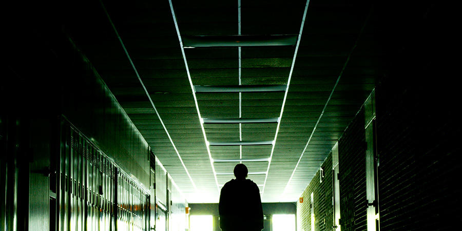 Person walking down dark hallway.