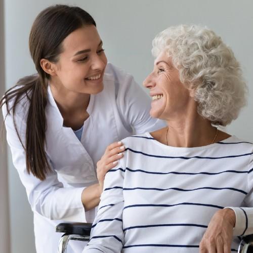 Specialist helping a senior woman in a wheelchair